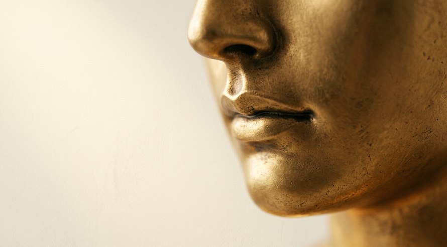 Escultura de rosto masculino em perfil dourado — arquitetura e discrição