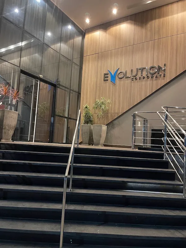 Entrada do Edifício Evolution Corporate vista da rua — escada de acesso e letreiro na recepção