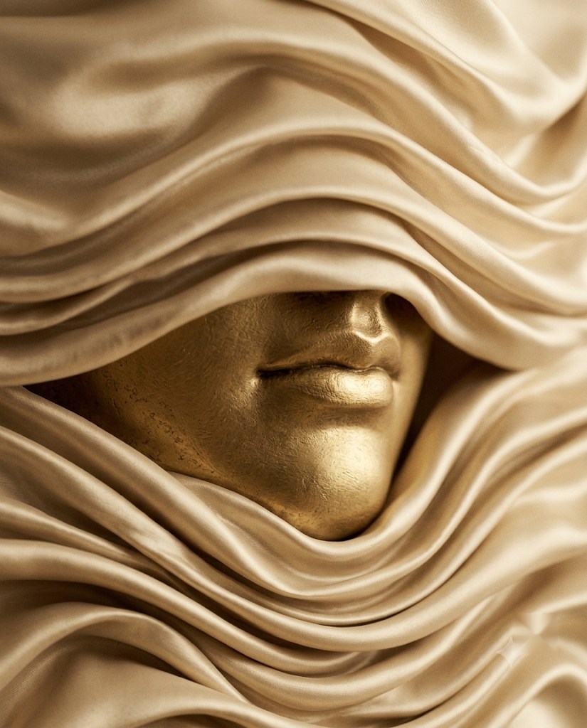 Lábios de escultura dourada emoldurados por seda — o desenho antes do volume